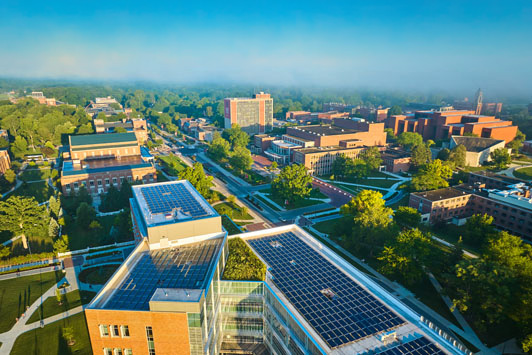 Aerial view of a university campus with rooftop solar panels and sustainable energy infrastructure