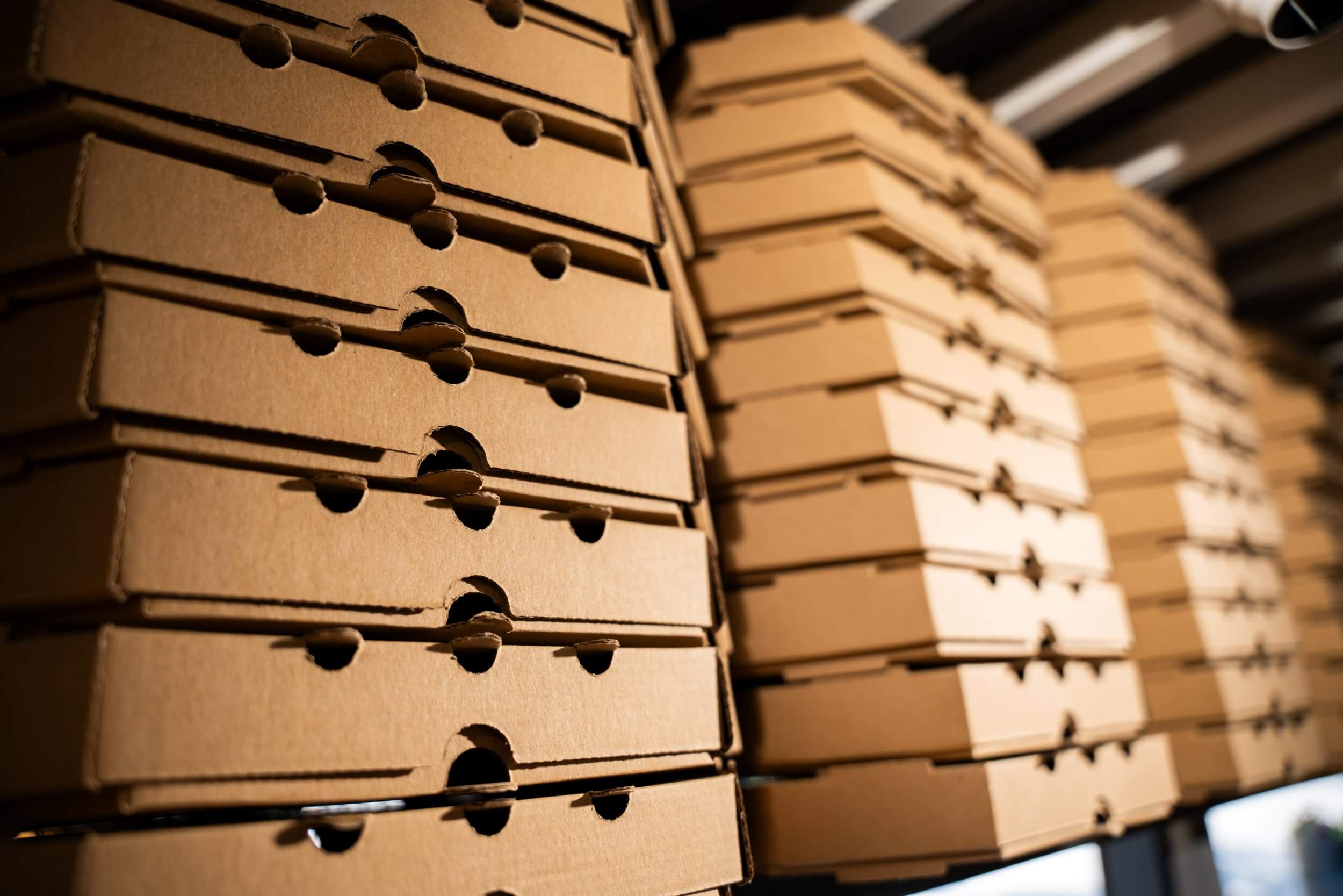 Pizza boxes stacked on a shelf