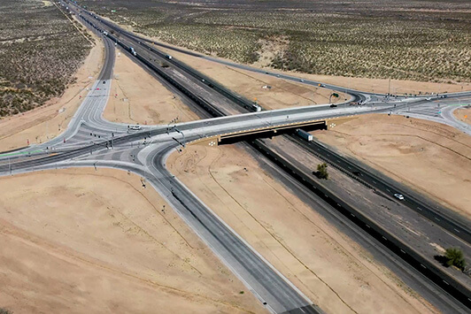 Aerial view of a highway interchange in a desert landscape with multiple connecting roads