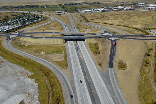 Aerial view of a multi-lane highway interchange with bridges and surrounding development